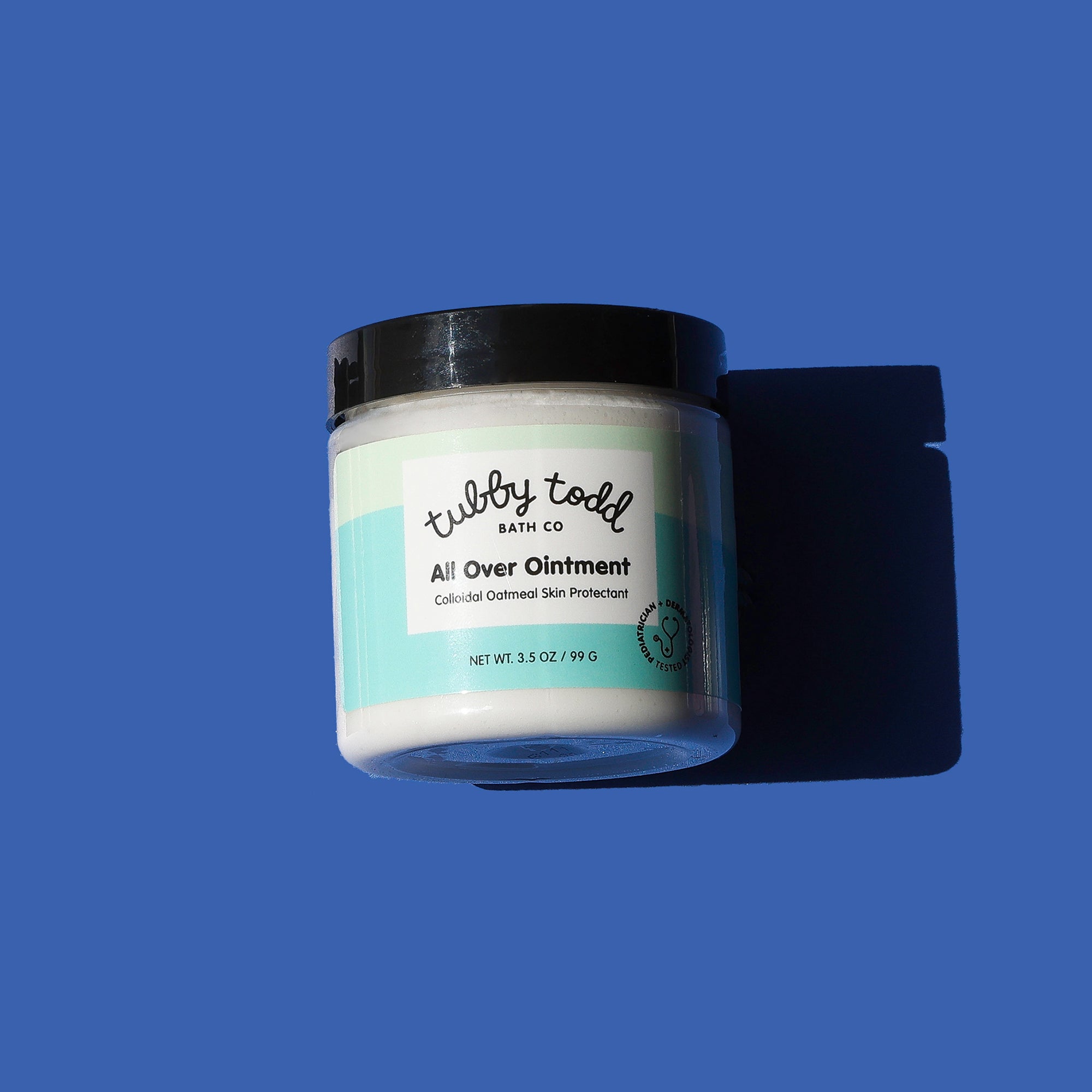 Jar of 'All Over Ointment' by Tubby Todd Bath Co on a blue background